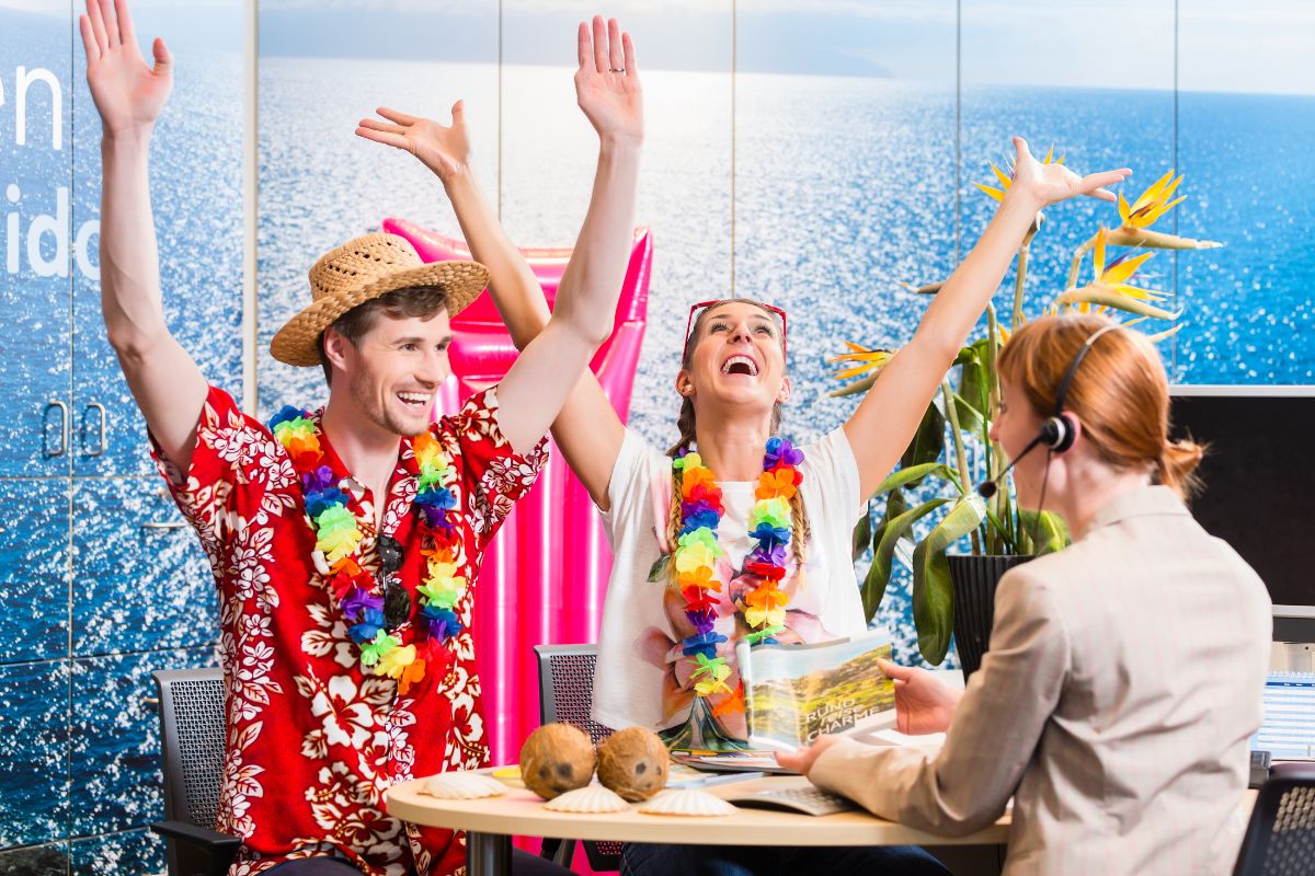 Un couple heureux dans une agence de voyage portant des vêtements de vacances colorés.