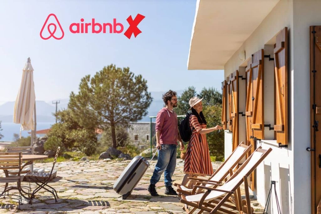 alternatives airbnb vacances : Couple avec valise arrivant à une maison de vacances.
