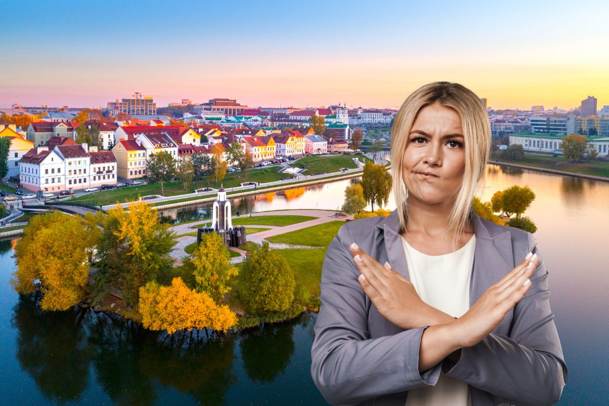 Femme montrant un signe d'interdiction devant un paysage urbain européen.