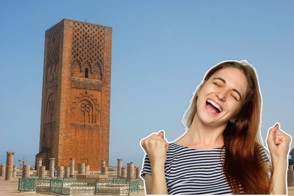 Une femme souriante devant la tour Hassan à Rabat.